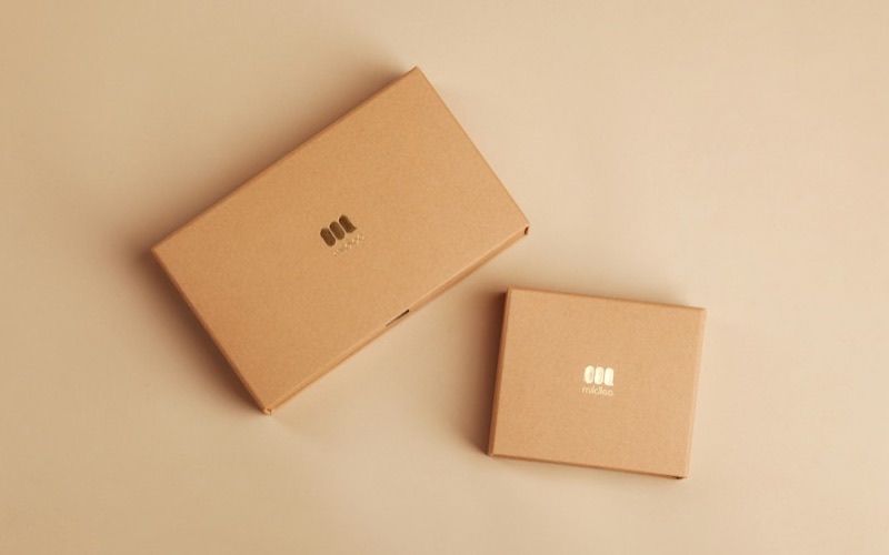 Two small cardboard parcels on a peach background
